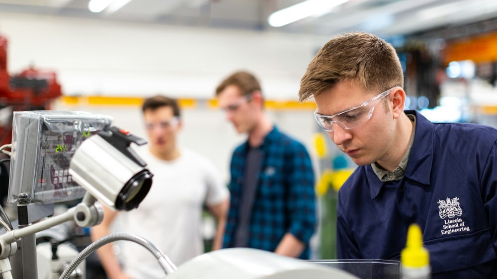 Savunma sanayii laboratuvarında gelişmiş elektronik devreleri ve optik sensörleri inceleyen mühendisler