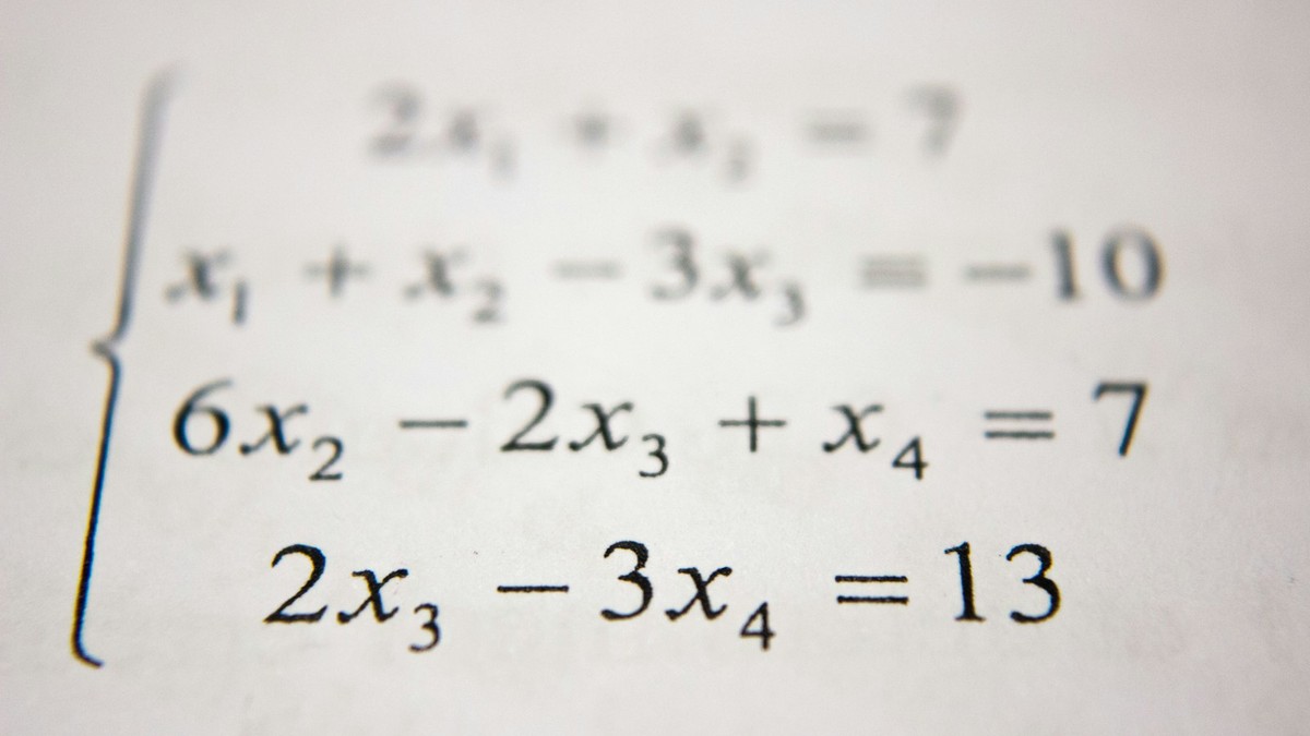 Üniversite amfisinde karmaşık matematiksel formüller ve geometrik teorem ispatlarıyla dolu kara tahta
