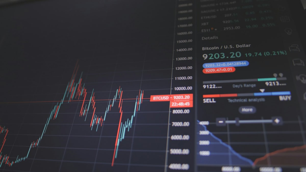 Finans merkezinde borsa ekranları ve şirket gelir tablolarını inceleyen analistler